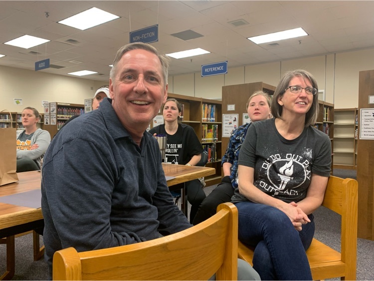 Teachers sitting at tables in a library