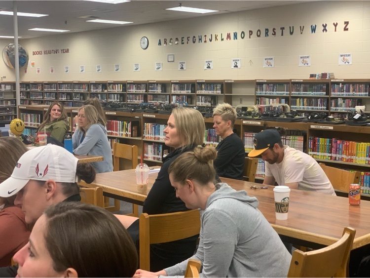 Teachers sitting at tables in a library