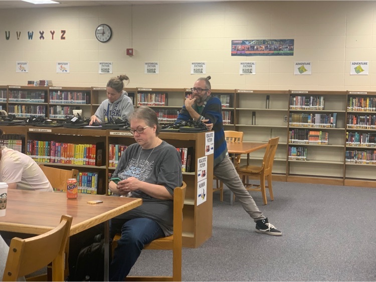 Teachers sitting at tables in a library