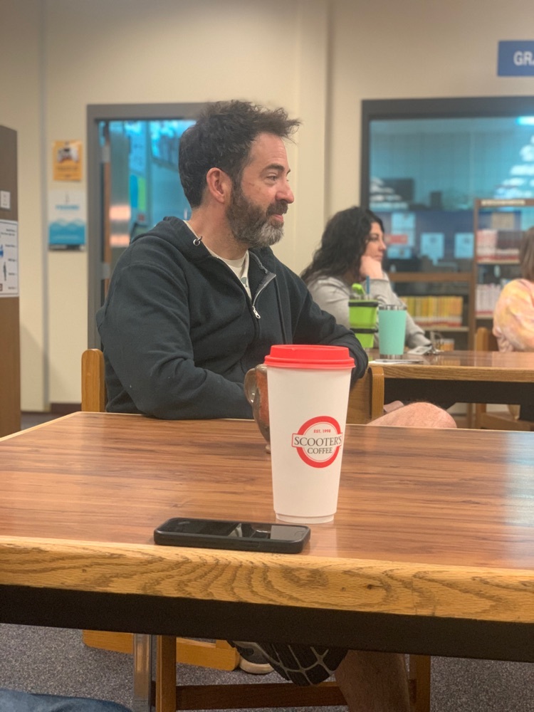 Teachers sitting at tables in a library