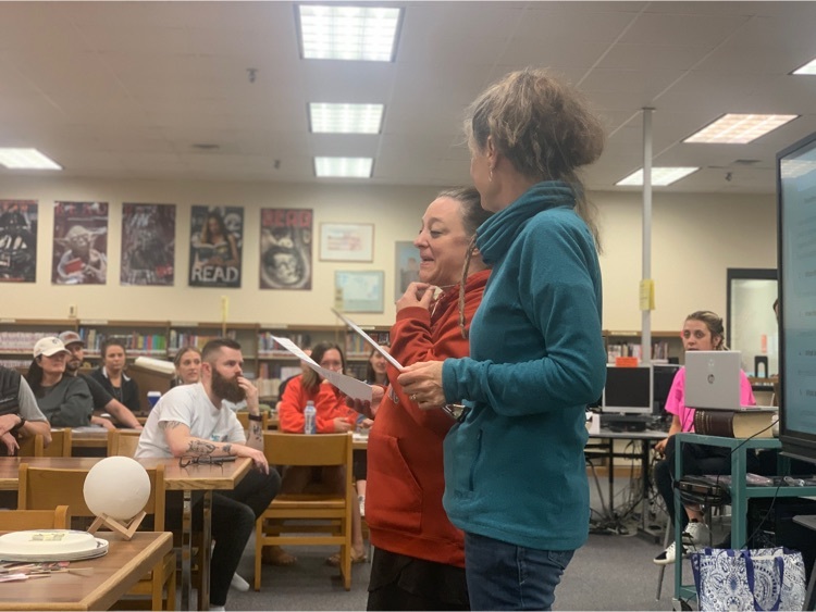 Teachers standing at tables in a library