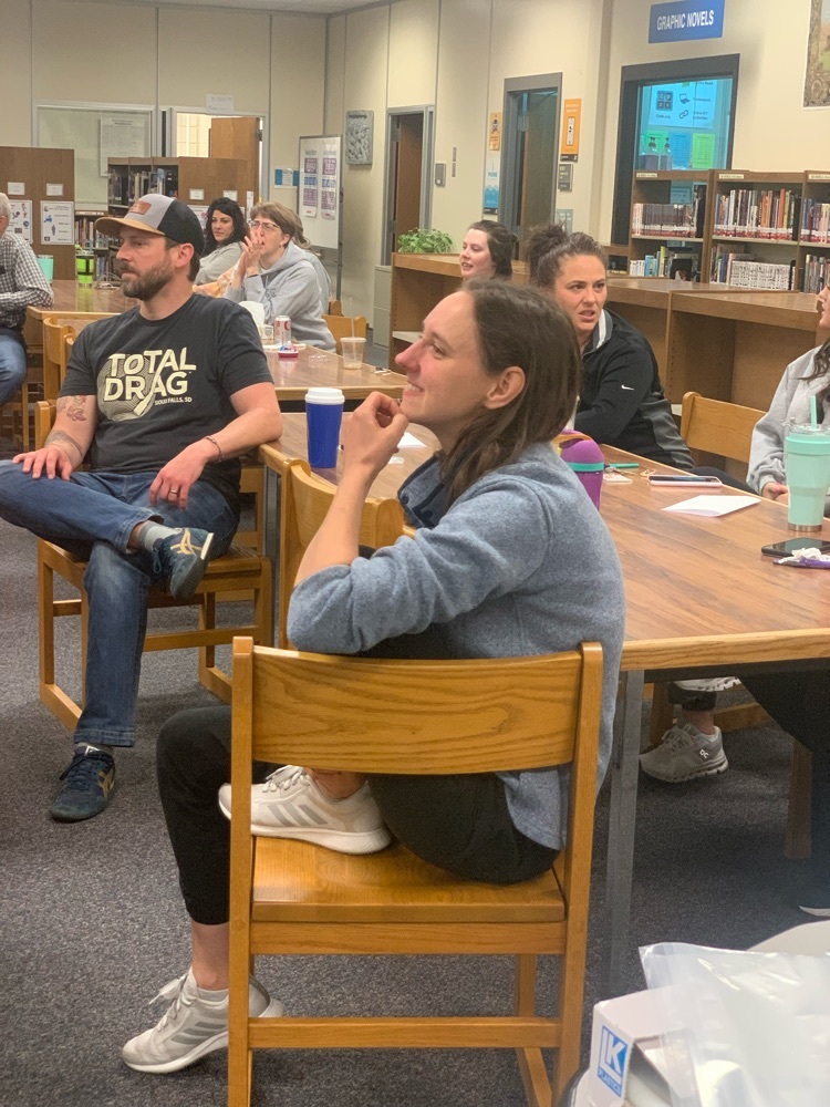 Teachers sitting at tables in a library